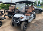Gray golf cart with brown seats on a dirt road