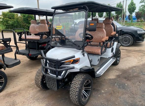 Gray golf cart with brown seats on a dirt road