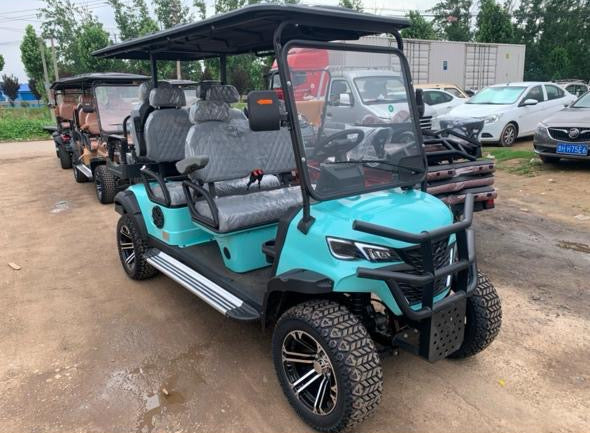 Turquoise golf cart on a dirt road with other vehicles in the background